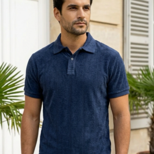 Homme portant un polo bleu marine texturé coupe classique avec un pantalon gris clair.